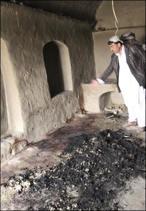 A man points to bloodstains, where witnesses say Afghans were killed by a U.S. service member, in Panjwai, Kandahar province south of Kabul, Afghanistan, Sunday.