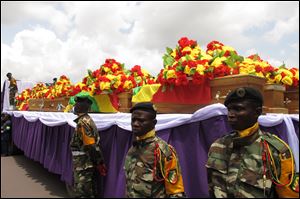 Soldiers guard coffins at the funeral in Brazzaville for victims of an explosion in the main military arms depot. Not all bodies could be identified in time for Sunday’s rite.