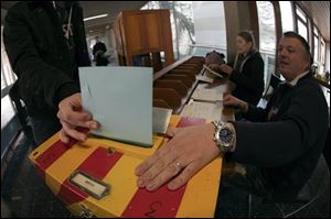 A man casts his vote in Carouge, Switzerland, Sunday. Swiss polls closed Sunday on several national referendums, including one to raise the minimum holiday from four weeks to six weeks, the standard used in Germany, Italy, Russia and many other European nations.  