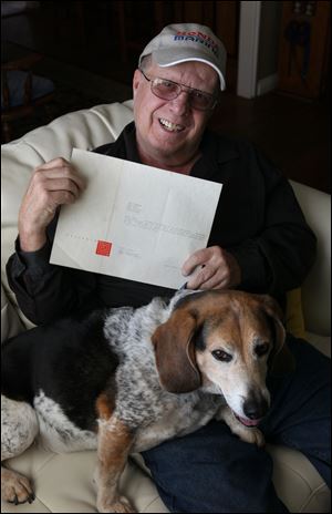 Jim Berger, with his dog Sir Charles Barkley, holds the letter the architect sent him.
