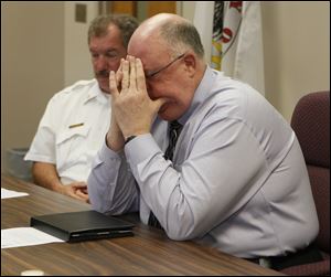 Marc Robinson, superintendent of Wauseon schools, foreground, listens with Marvin Wheeler, the city fire chief, in a news conference discussing the fatal shooting of a 13-year-old middle school student.