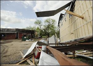 High winds propelled this piece of wood through a sign in front of Charlie's Ice House in Devine, Texas. The neighborhood bar was damaged when a tornado touched down Monday night in the town of 5000, about thirty miles southwest of San Antonio. 