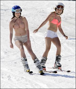 Sydney Warren, left, and Allie Ward, both 15 and from Prince Edward Island, Canada, enjoy the warm sun Wednesday while skiing in unusual weather for this time of year at Sunday River in Newry, Maine.