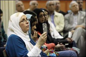 Toledoan Ghada Elkhatib records Jamal Badawi’s presentation. He said during a question-and-answer session that abuses of Sharia law in some countries give the world a distorted view of the code.