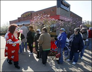 A costumed Erma greets those waiting in line to enter the Arrowhead Drive restaurant for its reopening.