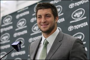 The quarterback beams during a news conference. Toyota could reap more than $2 million just from having its logo behind him.
