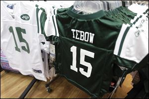 Reebok-manufactured jerseys with Tim Tebow's name and number on them are displayed at Modell's sports store in New York City.
