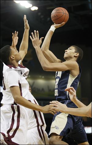 St. John's Jesuit player Marc Loving (32) shoots over Scott High's Reuben Pratt (20) during the Blade Classic in December.