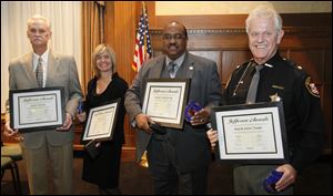 Showing off their awards are James Taylor, left, Norma Leslie (accepting for her husband, Ken Leslie), Jimmy Gaines, and Lucas County Sheriff's Maj. John Tharp. The Jefferson Awards are sponsored locally by The Blade, Buckeye CableSystem, and WTOL-TV, Channel 11. About 70 area residents were nominated this year, and a panel of judges pared the pool to 10 before selecting the four winners.