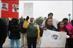 LaKaren Jones, left, LaQuita Richardson, Crista Parker, her dad, Chris Parker, and her sister Cheyann Parker join the crowd at the Toledo Public Schools administration building in North Toledo.