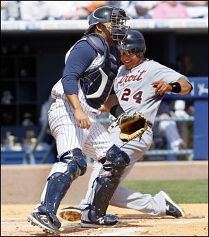 Detroit's Miguel Cabrera scores as Mud Hens catcher Omir Santos waits for the throw.