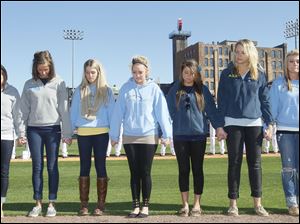 Alpha Xi Delta sorority members participate in a moment of silence for their three sorority sisters who were killed in a head collision on I-75 in early March before the Mud Hens home opener.