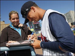 Mud Hens outfielder Quinton Berry (12) signs an autograph for Rachel McDuffee of Grand Rapids, Mich.