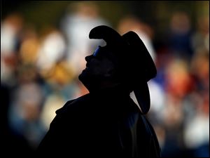 A fan watches a foul ball flies out of play.