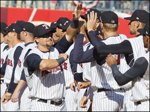 Mud Hens player Jerad Head (13) greets teammates before playing Indianapolis.