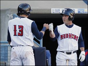 Mud Hens Jerad Head (13) is congratulated by Matt Young (6) after scoring in the sixth inning.