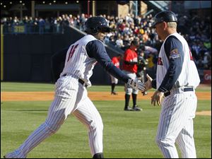 Mud Hens player Audy Ciriaco (16) low fives manager Phil Nevin as he rounds third base after hitting a home run in the second inning against Indianapolis.