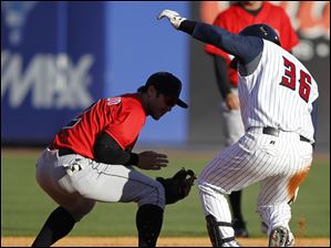 Mud Hens player Omir Santos is safe at second with a double to score a run as Indians player Chase d'Arnaud (2) has no chance.