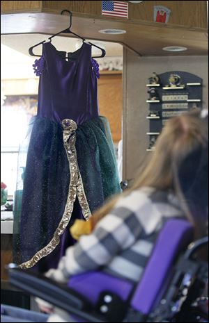 Brianna sits near her prom dress.