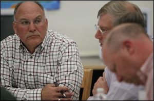 Lake school board President Tim Krugh, left,and Superintendent Jim Witt, right, listen to Treasurer Jeff Carpenter during a meeting to decide the size of a property tax levy.