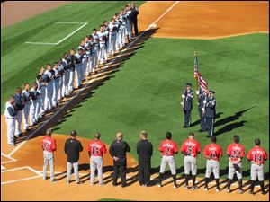 Toledo Mud Hens and Indianapolis Indians players bow their heads during the National Anthem at Fifth Third Field.