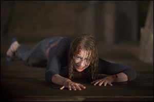 From left, Fran Kranz, Chris Hemsworth and Anna Hutchison explore 'The Cabin in the Woods.'