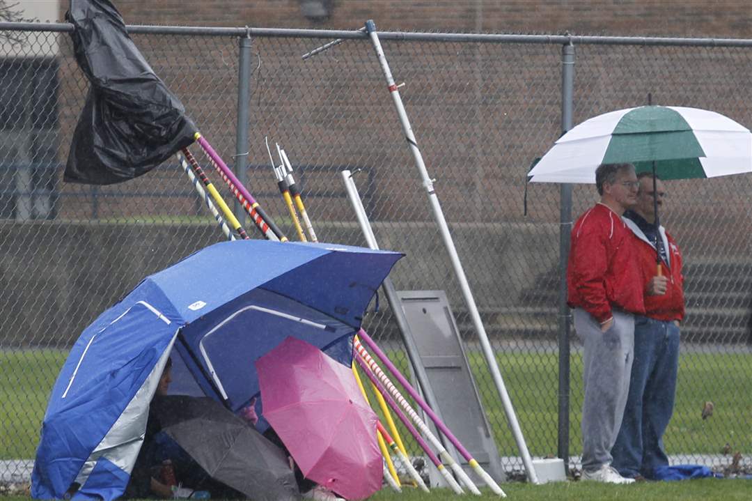 Athletes-hover-under-umbrellas-during-a-rainy-morning