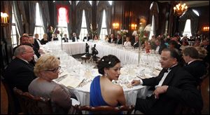 Juanita Kopan, center, and her husband Greg Kopan sit down to nine course meal.