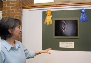 Gallery manager Karen Pugh shows Kim Kocinski's winning photo, 