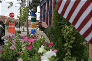 A stealth fiber artist wraps a parking meter post in downtown Toledo.