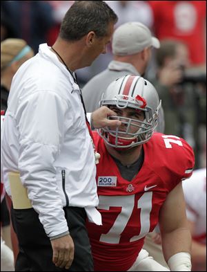 Ohio State’s Urban Meyer, left, talks with junior center Corey Linsley before the start of Saturday’s spring football game in Columbus.