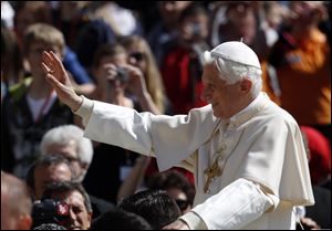 Pope Benedict XVI blesses faithful while touring St. Peter Square last week during the weekly general audience at the Vatican.