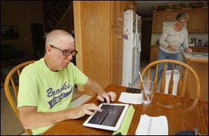 Tim Brooks of Oak Harbor, Ohio, communicates primarily with his iPad because amyotrophic lateral sclerosis — often called Lou Gehrig’s Disease — has hindered his ability to talk. His wife, Andrea, is in the background.
