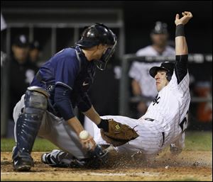 Chicago White Sox's Brent Morel, right, scores past Cleveland Indians catcher Lou Marson, off a single by Gordon Beckham and beating the throw from right fielder Aaron Cunningham, during the fifth inning of a baseball game Tuesday.