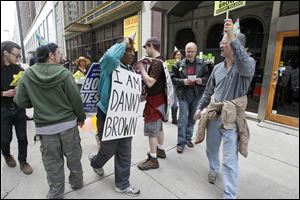 Danny Brown, center, pickets with allies at The 329, where Prosecutor Julia Bates was dining. He was imprisoned for a 1981 murder.