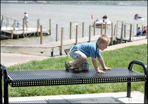 Four-year-old Nicolas Gilbert, Jr., plays on a park bench at Ed Cullen Park along the Maumme Bay in Point Place.