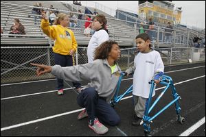 Antoinette Cobbler of Whitmer High, foreground, works with
Cadiel Santana, 6, of Hiawatha Elementary as Bailey Kurdys of Washington Junior High coaches Trey Prentice, 9, of Jackman Elementary.