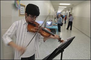 Sixth-grade student Arman Serpen plays the violin at Timberstone Junior High's open house. Included among the technology projects were cars powered by mousetraps, a prosthetic hand, and a catapult.