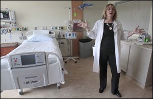 Kelly Joseph, a registered nurse and stroke care coordinator at Toledo Hospital, shows off a patient room. Its 'telemedicine' technology allows doctors to examine and treat patients quickly. 