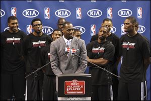 Surrounded by teammates, Miami Heat's LeBron James speaks after having accepted the NBA MVP trophy, Saturday, in Miami. Calling the honor 