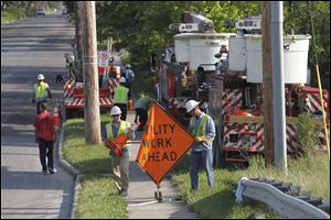 Toledo Edison workers prepares to cut off the power of a live wire that was felled by a truck along  I-475 in Toledo, Ohio.