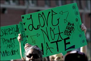 Marchers carry signs opposing violence during the rally that began on Delaware and Lawrence streets.