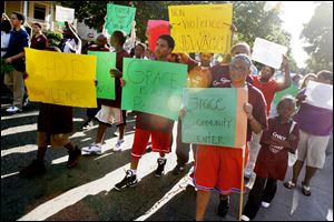 Young people from Toledo’s schools and programs march down Collingwood Boulevard toward Scott High School Thursday accompanied by local educators, community leaders, and city officials.
