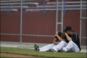 Ottawa Hills' Adam Moreau, left, is consoled by hitting coach Nick Whetstone after the Green Bears fell in the regional semifinal. Moreau had a pair of hits in the loss.