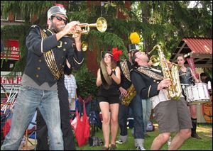 The Detroit Party Marching Band, including John Notarianni on trumpet, left, Elle Gotham, on cymbals, and Paul Mardirosian, on tenor, all of Detroit, play at last year's Old West End Festival.