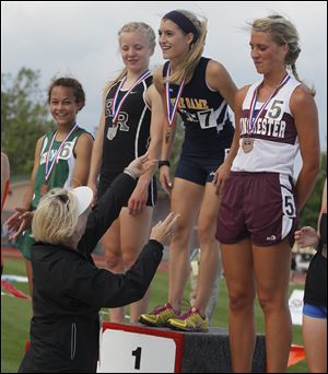Notre Dame's Lexi Aughenbaugh receives her medal at the top of the awards podium after winning the 3200- meter race in the Division I state meet