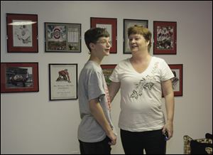 Jarred Wise, 13, with his mother, Lee, gets his first look at the renovated basement of the family's home in Whitehouse. Jarred, an avid fan of the Ohio State Buckeyes, is recovering from a bout with leukemia.