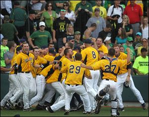 Oregon fans watch with disappointment as Kent State players celebrate a 3-2 victory in the bottom of the ninth inning during the final game of their NCAA college baseball tournament super regional game, Monday.