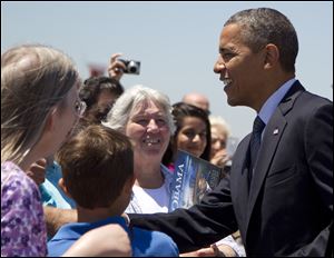 President Barack Obama greets people on the tarmac as he arrives at Cleveland-Hopkins International Airport in Cleveland.