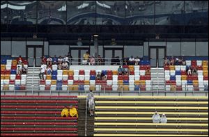 Die-hard  fans try to stay dry during a two-hour rain delay  of the Quicken Loans 400 at Michigan International Speedway.